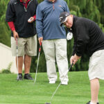 Joe O’Loughlin of Wells Fargo Bank (left) and Richard Beretta of Adler, Pollack and Sheehan (middle) watch Jon Sachs of Adler, Pollack and Sheehan make a putt.