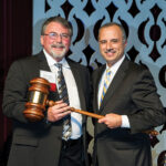 Bob Bacon, outgoing chairman of the RI Hospitality Association, passes the gavel to 2016 incoming Chairman, Bahjat Shariff of Howley Bread Group.