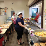 Lynette Lamberti, Human Resource Coordinator with Tony Lodato, Check-In Driver, preparing sandwiches