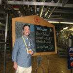 Greg Zannella, General Sales Manager with the “Beer School” welcome sign during the brewery tour.