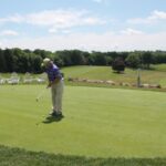 Golfers practicing puts before the start of the tournament.