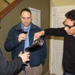 Milton Monzon, Commercial Director of J.C. Imports, pouring wine for David Forte and Richard Lupino of Knights of the Wine Table of Rhode Island.