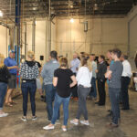 John Taylor (left in blue), Co-owner of Waypoint Spirits, leading a tour of the distillery for CRA and industry members during the CRA Spring Potluck event.