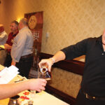 Tim Boynton of Rhode Island Distributing, Co. pouring a sample for Peter Vigeant of Gasbarro’s Wines.