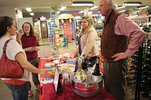 A guest tastes Carpene Malvoltti Prosecco paired with Deep River’s Spicy Dill Pickle chips. Store manager Jill Merola with Sarah Wadle and Matthew Carpenter look on.