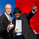 Incoming RIHA Chairman of the Board Angelo DePeri presents Isiah Tsimonjela, line cook at the Hilton Providence, with his Hotel Employee of the Year award.