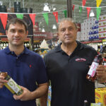 George Mitas, Purchasing and Sales Manager, Mina Distributors, holding Muses Estate White Dry; Dimos Mitas, Owner, Mina Distributors, holding Muses Estate Rose Dry.