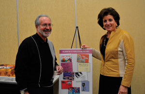 Paul Agranovitch, Owner of Universal Discount Package, with wife, Linda, in front of the invitations sent over the years for their annual event.