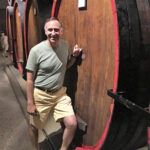 Julius Angelini next to a grappa di Prosecco barrel at the Carpenè Malvolti estate. Carpenè Malvolti ages some of their grappa in large barrels, often seen used when aging wine.