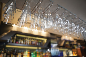 Many wine glasses hanging above the bar