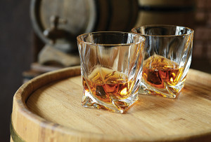 Glasses of brandy in cellar with old barrels