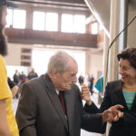 Former Narragansett Brewing Company employee Joseph Ianaire, who worked at the company for 34 years, next to Gov. Gina M. Raimondo during a tour of the Isle Brewers Guild facility in May. Isle Brewers Guild is now home to Narraganset Beer’s brewing operations.