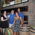 All from J. Timothy’s Taverne: Lauren Hansen, Bartender and Supervisor; Tim Adams Co-owner; Marrit Budny, Bartender and Supervisor; Sean Murphy, Manager with a bottle of Old Forester.