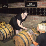 Lauren Hansen, Bartender and Supervisor, J. Timothy’s Taverne, pulling a bourbon sample from one of the Old Forester bourbon barrels.