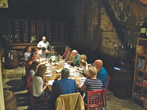 Bob Morus leads a discussion, surrounded by wine barrels, racks and candelabras. 